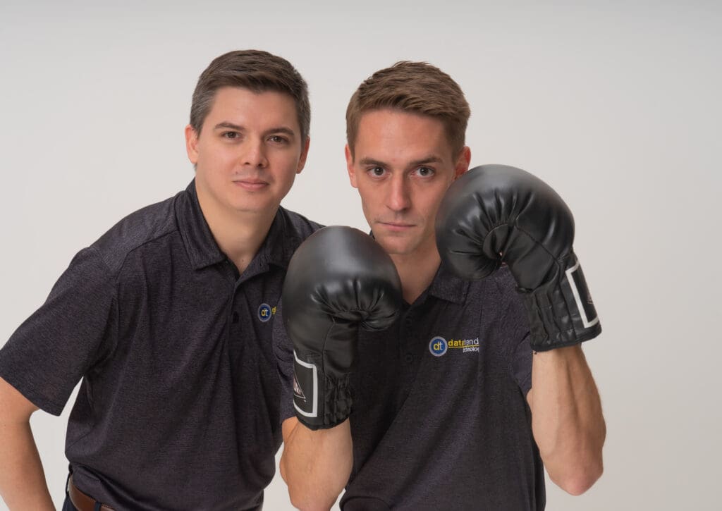 Pair in company polos, one wearing boxing gloves