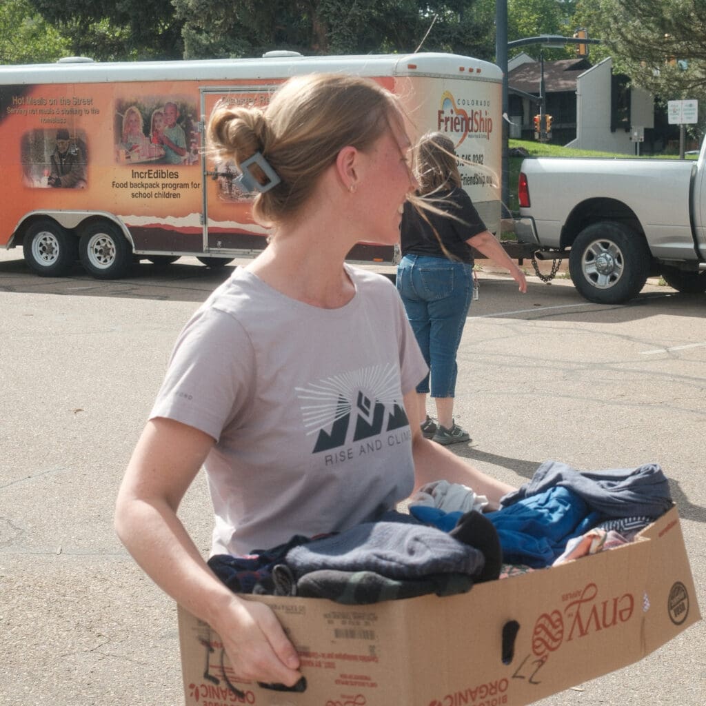 Volunteer carrying box of donated clothing