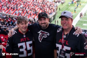 Three Atlanta Falcons fans smiling in stadium