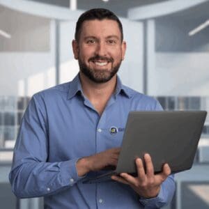Bearded professional holding laptop in modern office